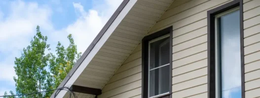 The side of a residential home with with new brown and tan Siding, Soffit & Fascia installed by Prairie State Siding