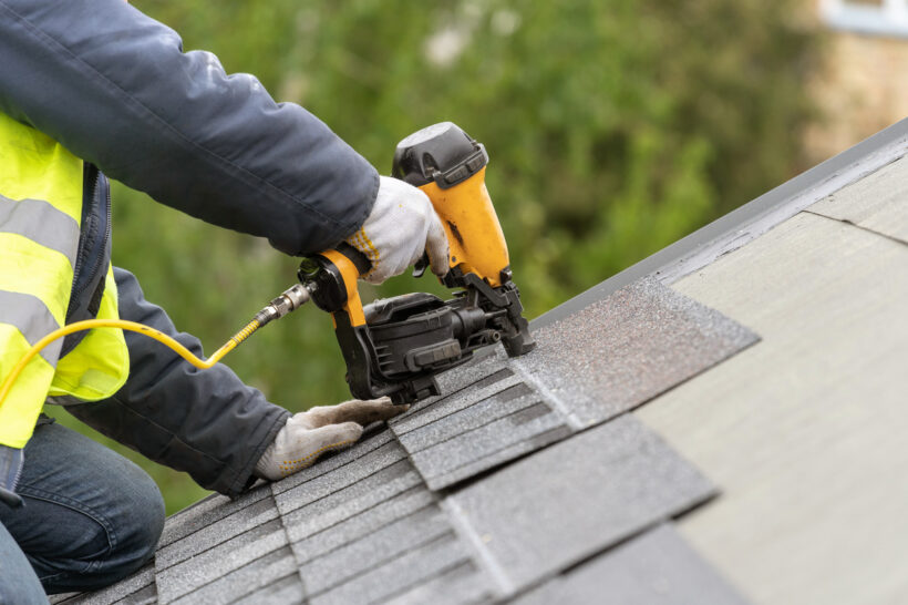 A worker from Prairie State Siding, a Peoria-based roofing company, puts on a new roof